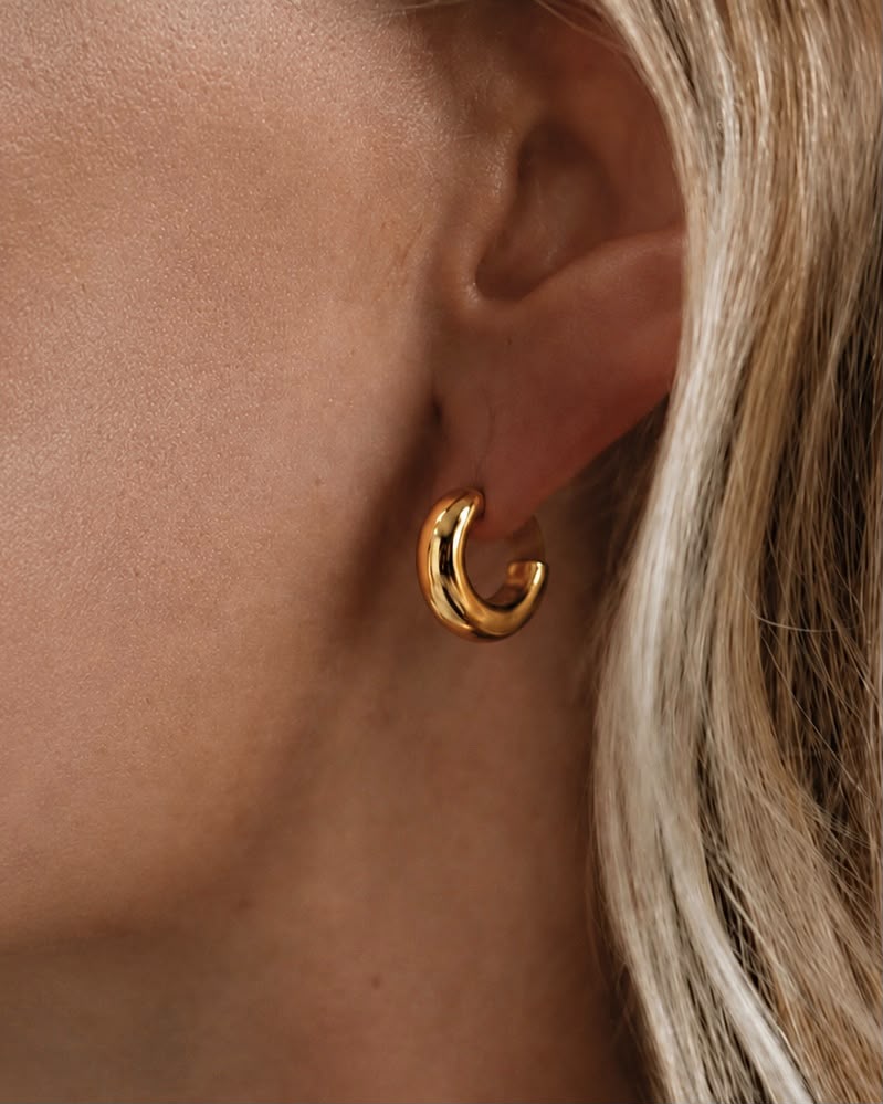Kvinna som bär Rizo Classic Hoops 10 mm i guldbeläggning